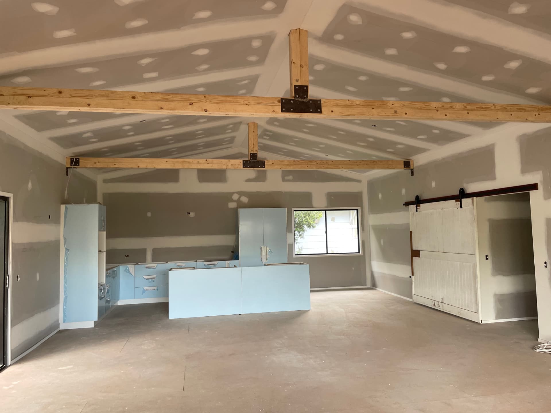 Exposed timber feature beams and posts in a finished open-plan interior