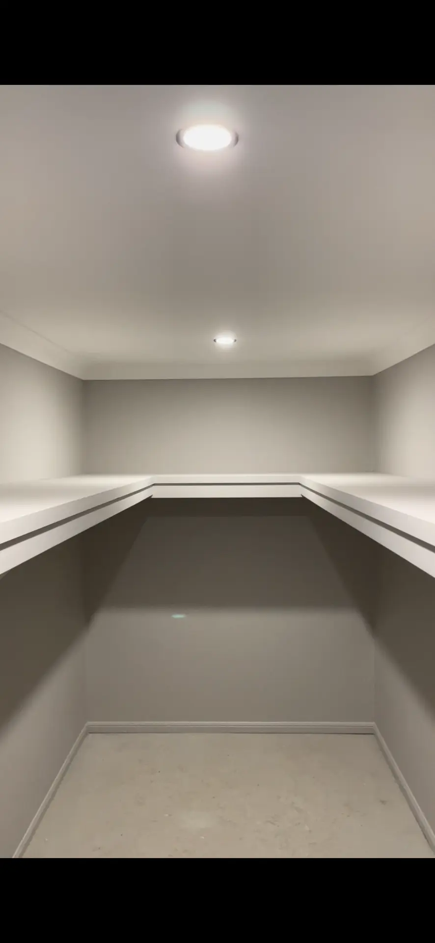 Finished built-in wardrobe with shelving, hanging rails and lighting